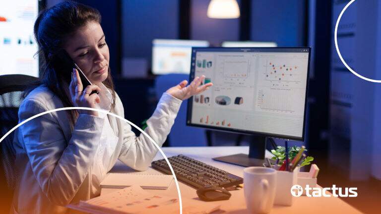 Imagem mostra jovem mulher à frente de computador om gráficos, falando ao telefone com rosto de dúvida, perguntando ao contador se gestor de tráfego pode ser MEI