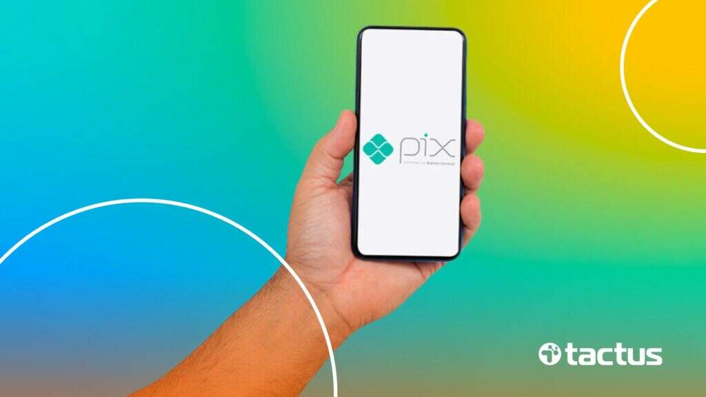 Imagem mostra mão mostrando celular com a logo do PIX, para simbolizar a dúvida se o PIX vai ser taxado em 2025