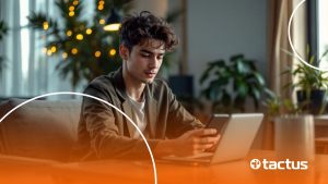Jovem mexendo no computador com celular à mão, simulando como monetizar no tiktok