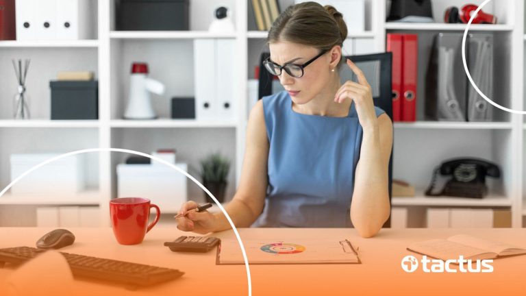 Imagem mostra mulher de negócios em sua mesa analisando números na calculadora, como se estivesse se preparando para a reforma tributária para e-commerce