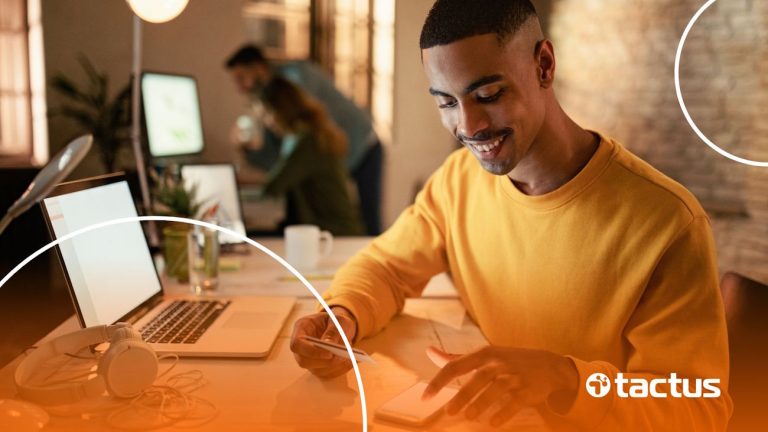 Imagem mostra jovem mexendo no celular com cartão de crédito na mão, para simbolizar qual a melhor conta de banco digital PJ gratuita