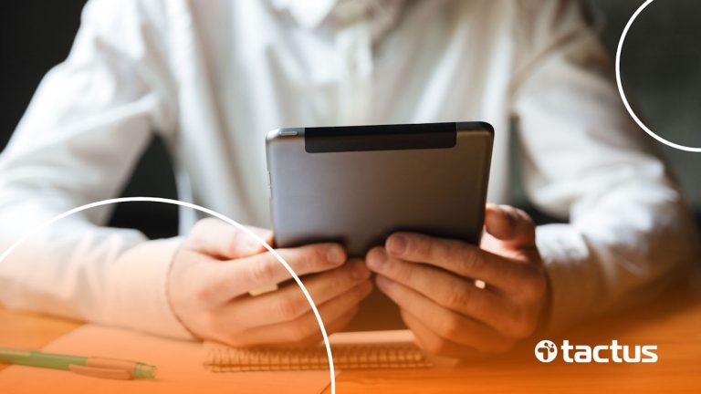 Mãos segurando um tablet, simulando a tributação das vendas de e-book no Simples Nacional