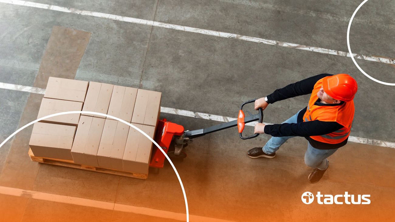 Imagem mostra funcionário de logística carregando caixas num carrinho, para ilustrar o que é cross docking