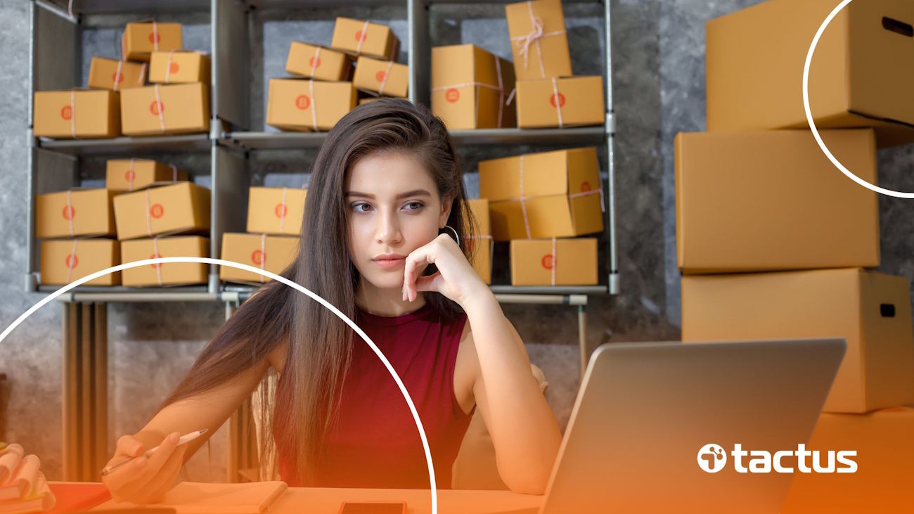 Imagem mostra jovem no notebook com caixas ao fundo, para simular se o mercado livre emite nota fiscal para CNPJ