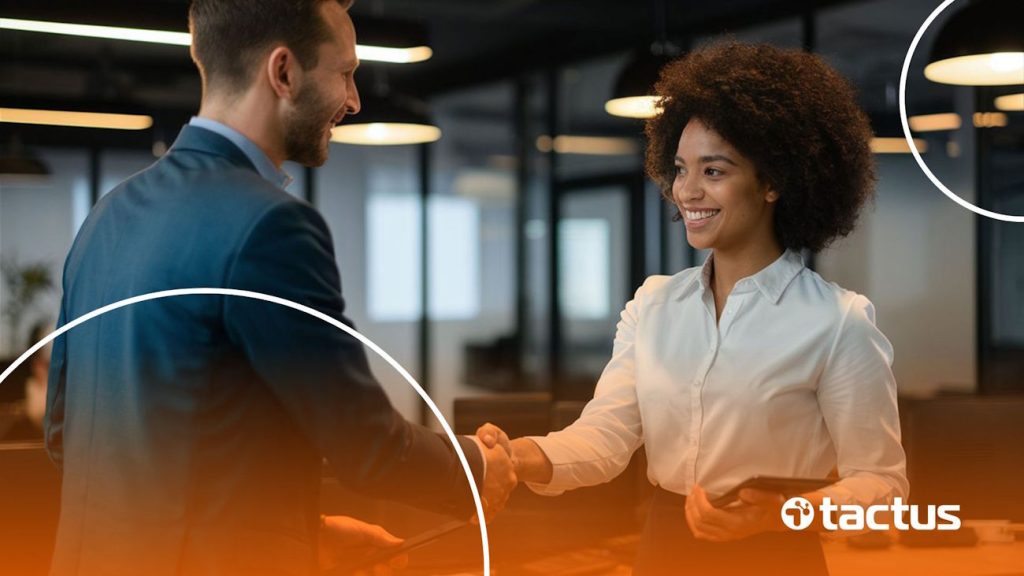 Duas pessoas sorrindo em ambiente corporativo se cumprimentando, para simular a parceria com preposto de representante comercial