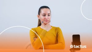 Imagem mostra jovem mulher olhando ao celular com o rosto pensativo, como se perguntasse se TikToker pode ser MEI