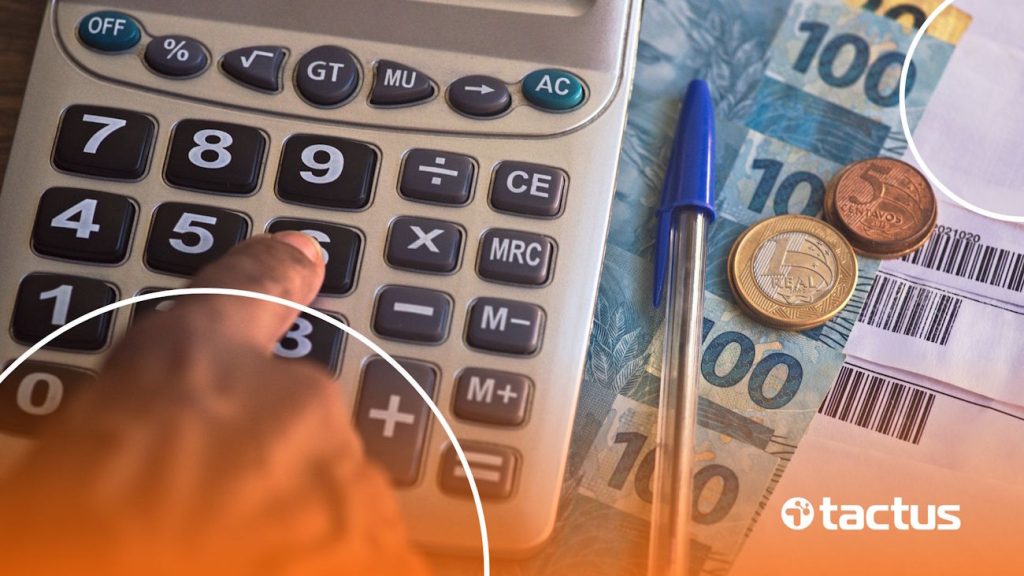 Mãos mexendo em calculadora com notas de reais ao lado, para simular as mudanças no Lucro Presumido em 2026