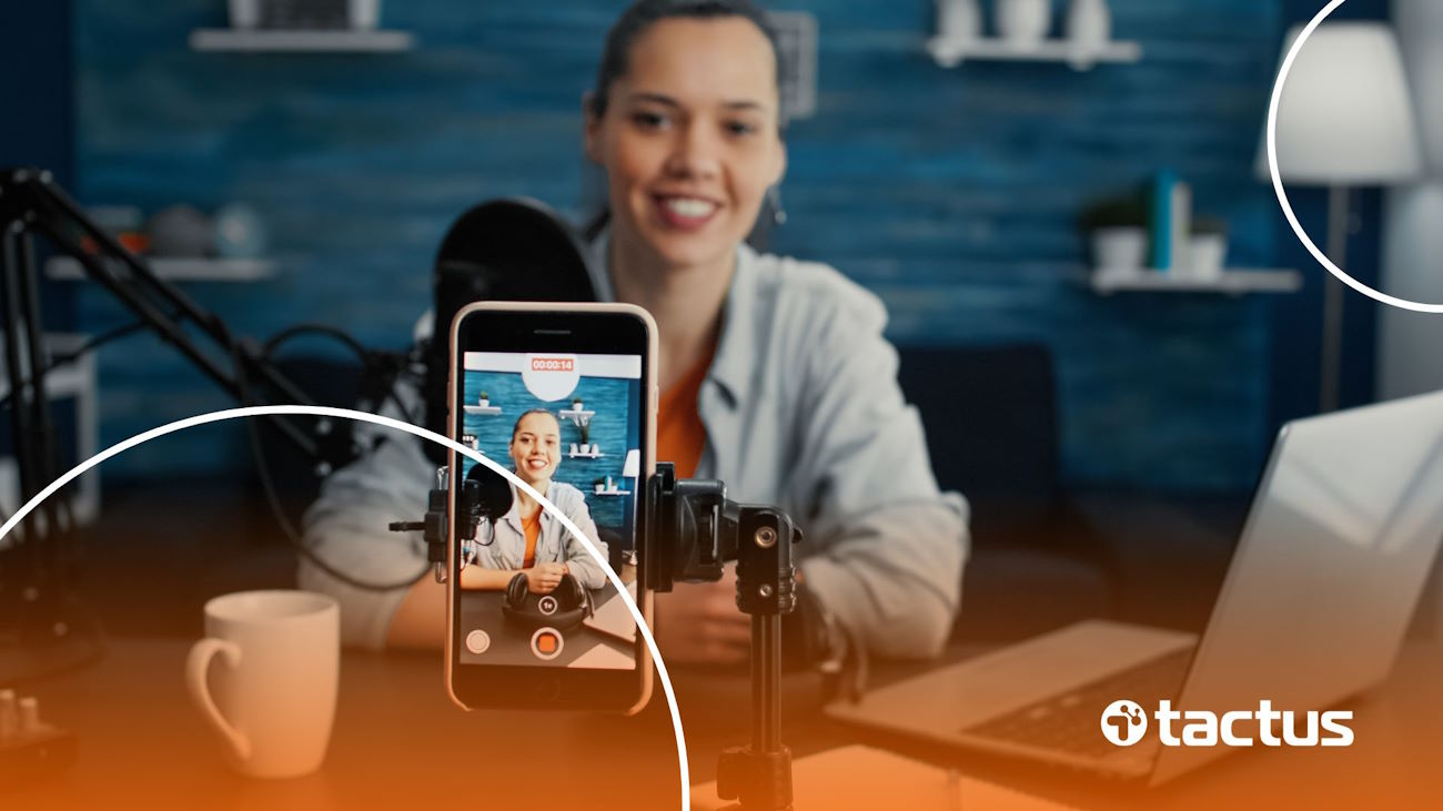 Influenciadora digital sorrindo para o celular, ilustrando o que muda com a lei dos influenciadores digitais e profissionais multimídia