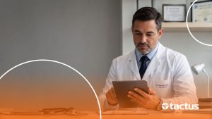 Imagem mostra médico de meia idade em seu consultório mexendo no tablet, como se pesquisasse os impostos para médicos da sua clínica