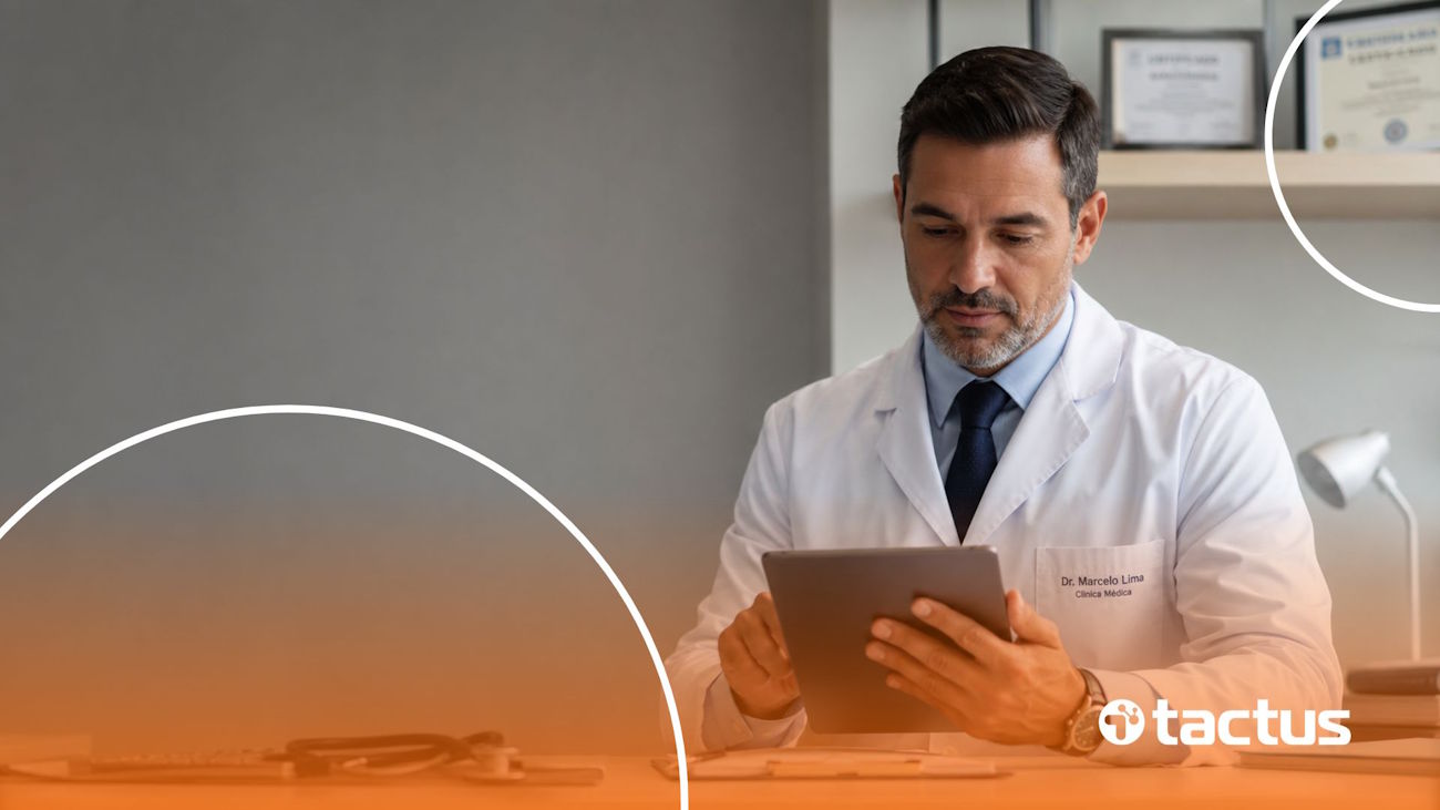 Imagem mostra médico de meia idade em seu consultório mexendo no tablet, como se pesquisasse os impostos para médicos da sua clínica