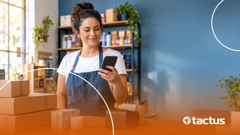 Dona de loja confere um pedido no celular atrás do balcão, porque o MEI pode emitir nota fiscal de produto nas vendas que faz
